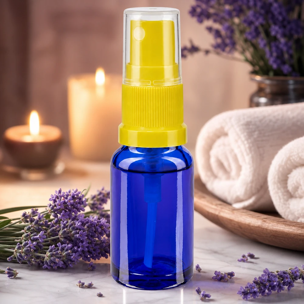 Accessori per l'aromaterapia: flacone spray blu da 30 ml con erogatore giallo accanto a fiori di lavanda