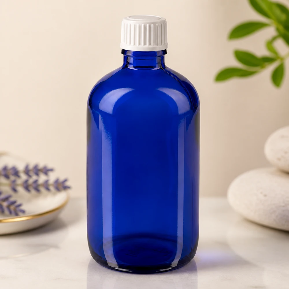 100ml blu apofl. SV STD bianco/11mm ApoGlas Flacone di vetro blu da 100 ml con tappo di sicurezza per bambini bianco, su una superficie di marmo accanto alla lavanda