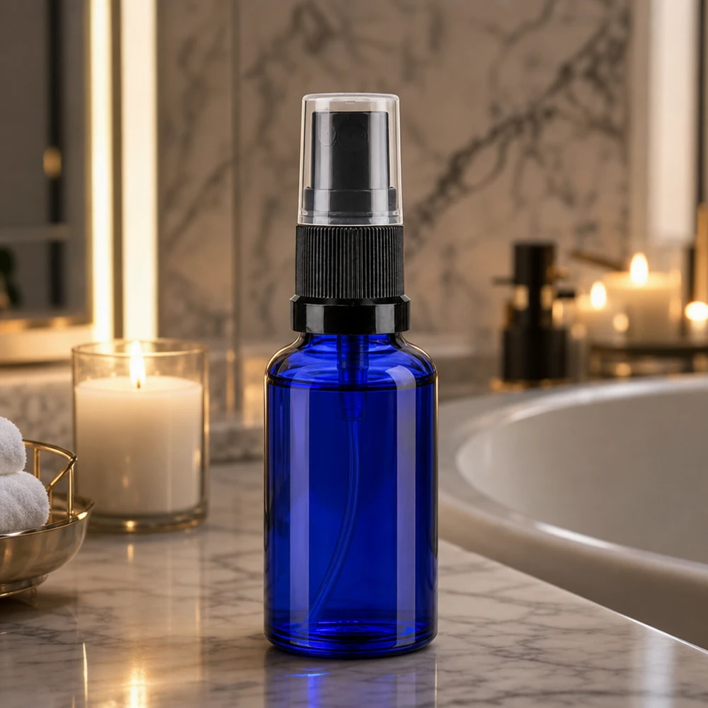 Bottiglia spray blu da 20ml. STD nero/trasp. apoGlas Flacone di vetro blu da 20 ml con nebulizzatore in un ambiente da bagno in marmo