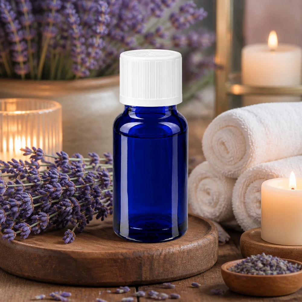 Flacone di vetro blu da 10 ml con tappo di sicurezza per bambini bianco, tra fiori di lavanda e candele