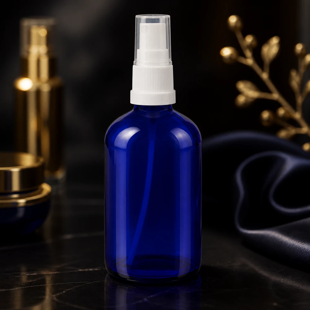 Flacone spray blu 100ml STD bianco/trasp. apoGlas Flacone in vetro da 100 ml di colore blu cobalto con erogatore bianco e tappo protettivo trasparente