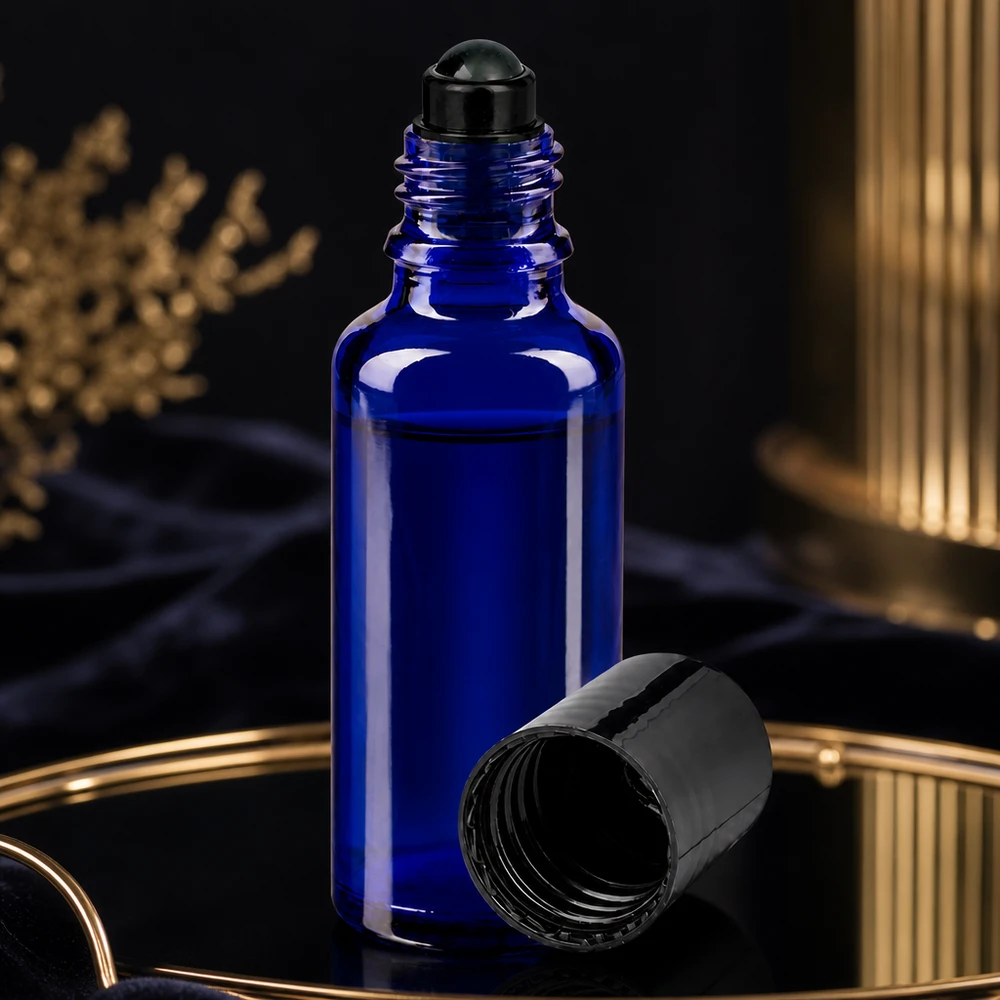 Flacone roll-on 30ml blu STD nero ApoGlas Flacone roll-on blu da 30 ml con tappo a vite nero aperto su un vassoio dorato