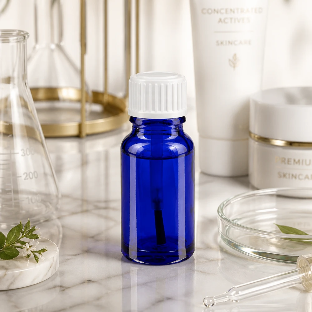 Bottiglia per pennelli 10ml blu STD bianco ApoGlas Piccola boccetta di vetro blu da 10 ml con tappo a vite bianco su una superficie di marmo, tra gli strumenti da laboratorio