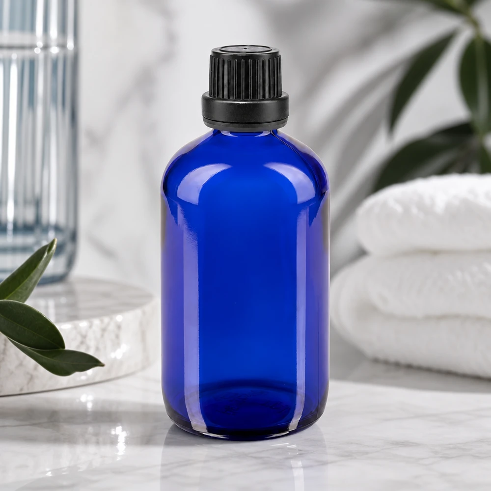 Bottiglia da farmacia blu da 100 ml. SV OV nero/11mm ApoGlas Bottiglia di vetro blu da 100 ml con tappo nero a coste, accanto ad asciugamani bianchi e piante verdi