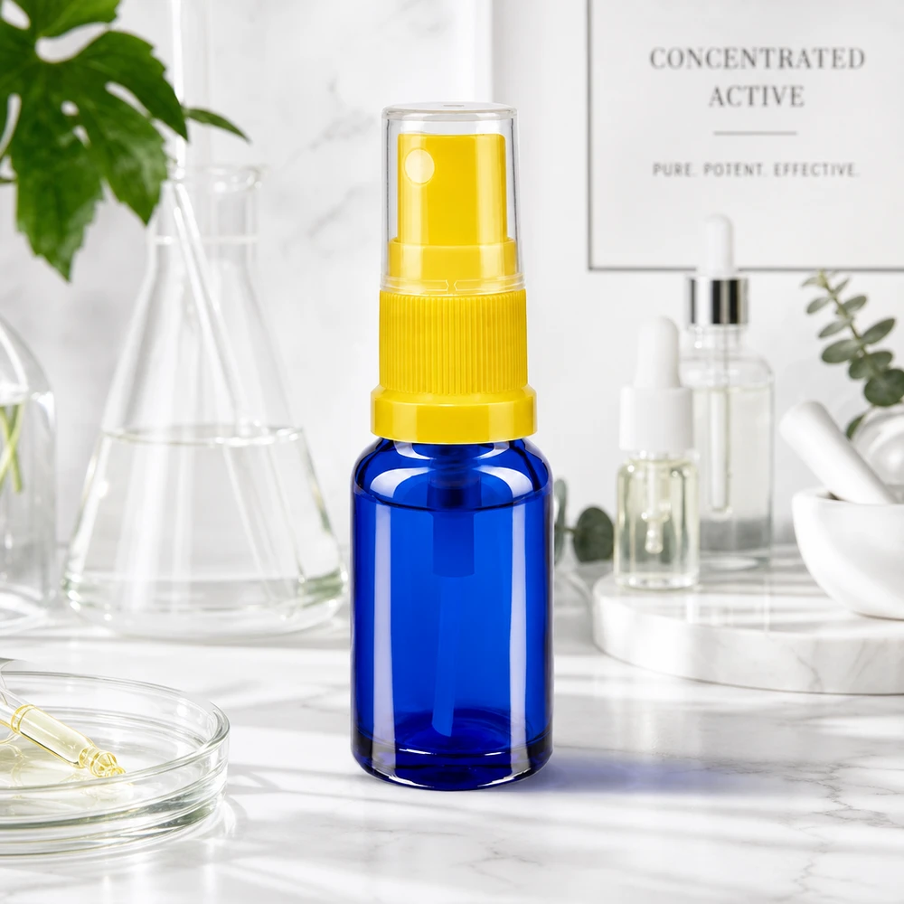 Flacone blu da 10 ml con erogatore giallo e tappo di protezione su una superficie in marmo bianco