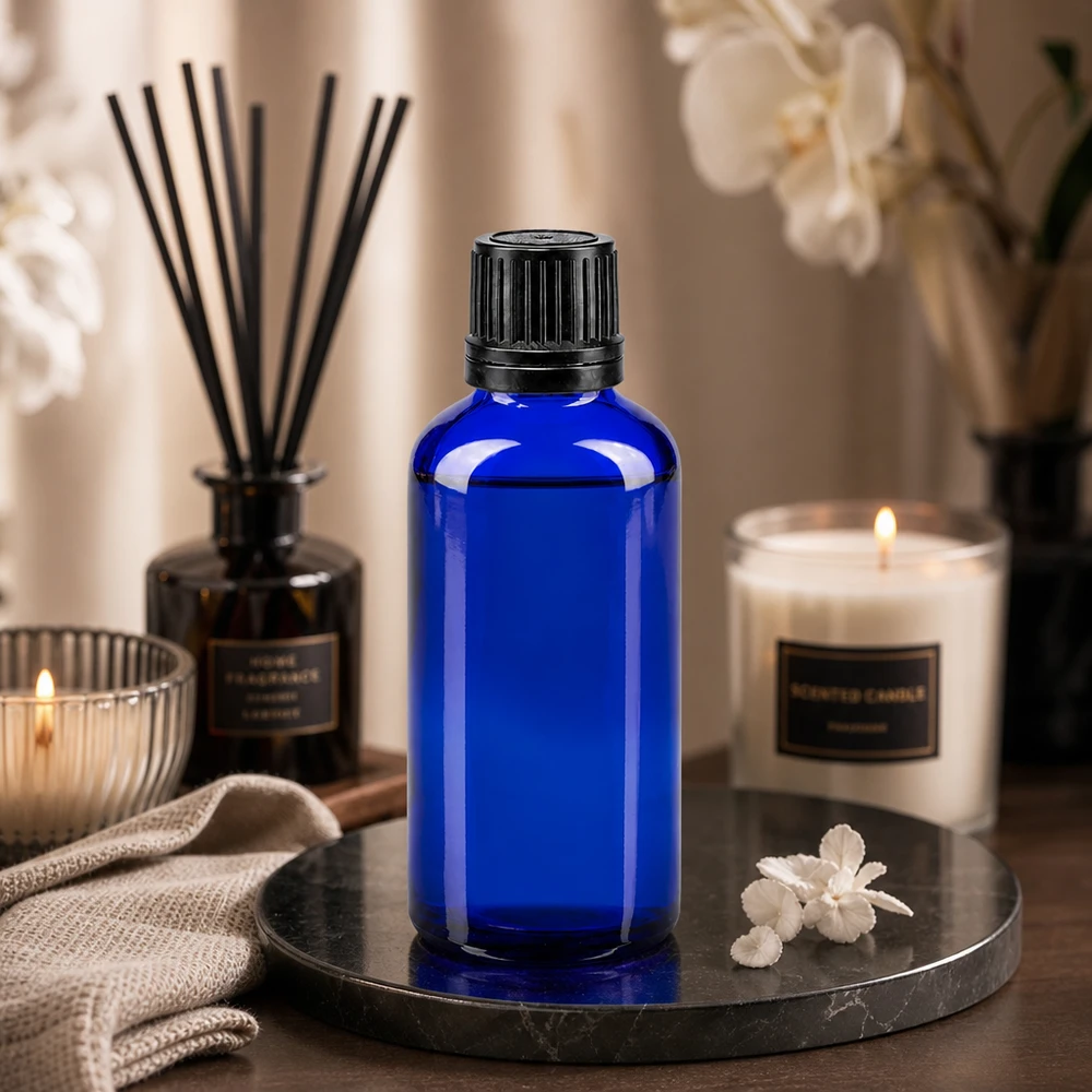 Flacone 50ml blu (Glo.)GR OV nero/8mm ApoGlas Flacone di vetro blu da 50 ml con tappo a vite nero, su un vassoio di marmo con candele e profumo per ambienti
