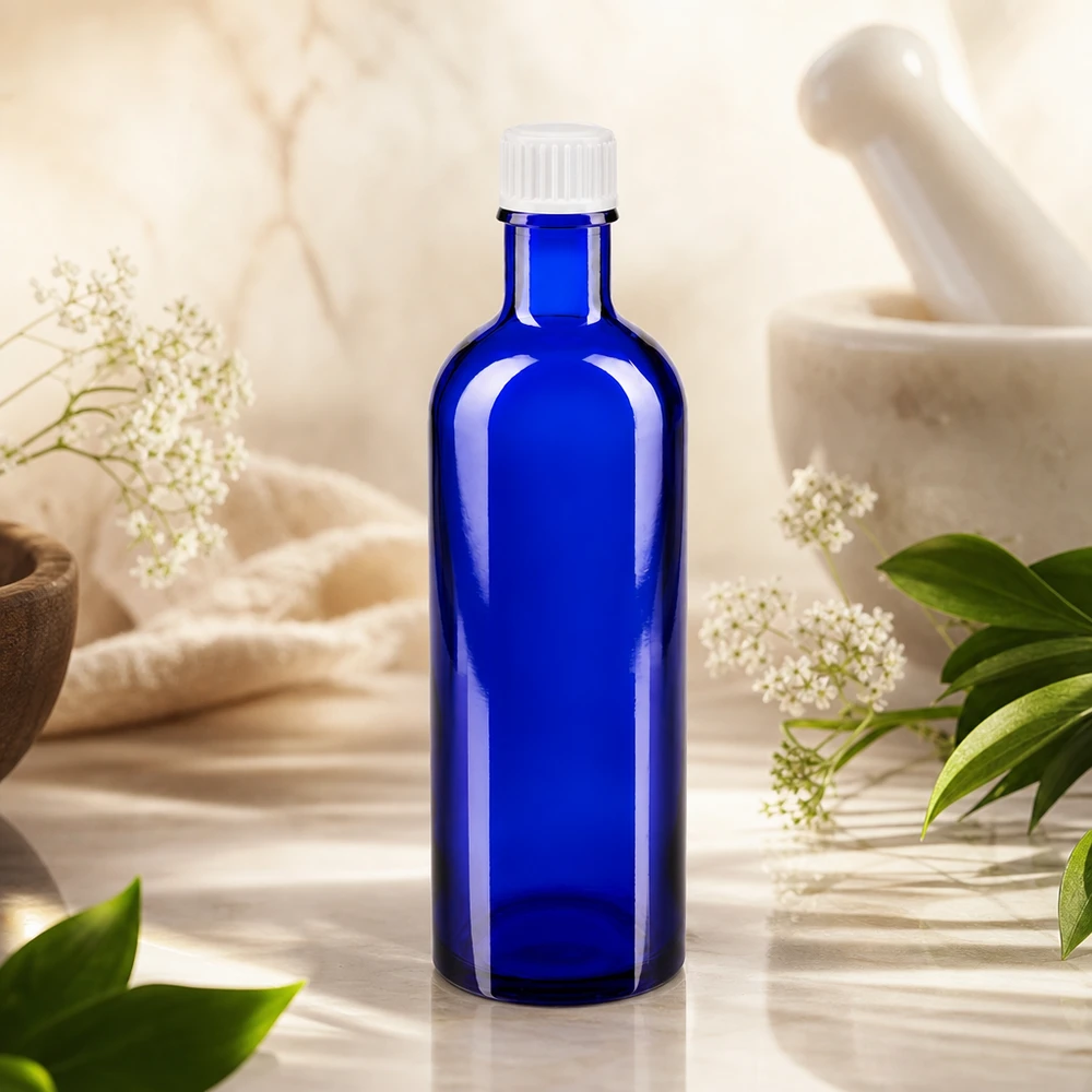 Flacone da farmacia blu da 200 ml con tappo a vite bianco, tra erbe medicinali e un mortaio