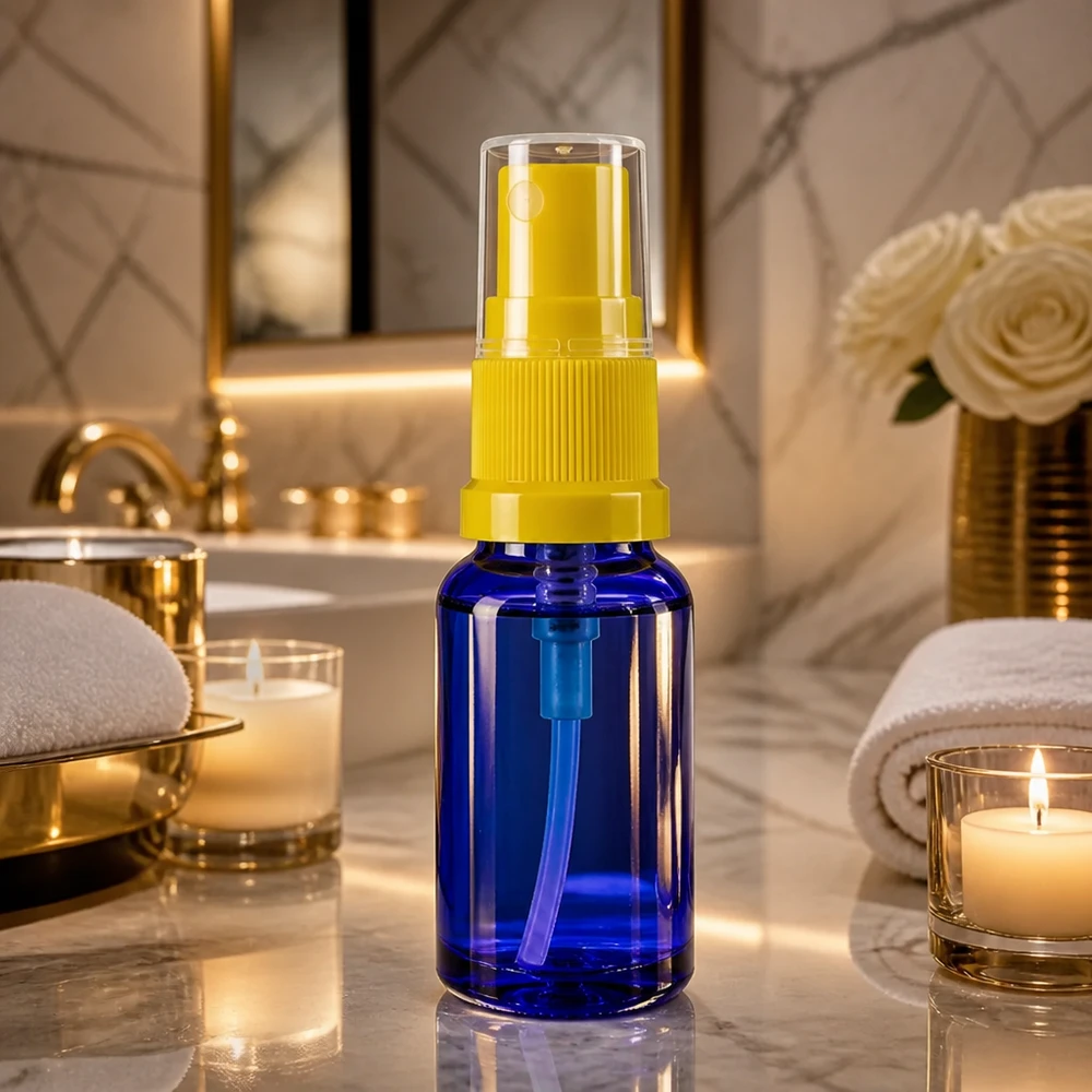 Piccolo flacone spray in vetro blu da 30 ml con erogatore giallo su sfondo marmorizzato
