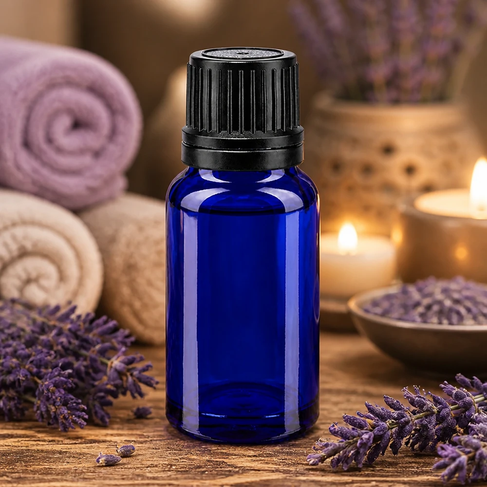 Piccolo flaconcino di vetro blu da 10 ml con tappo originale nero, circondato da fiori di lavanda e candele