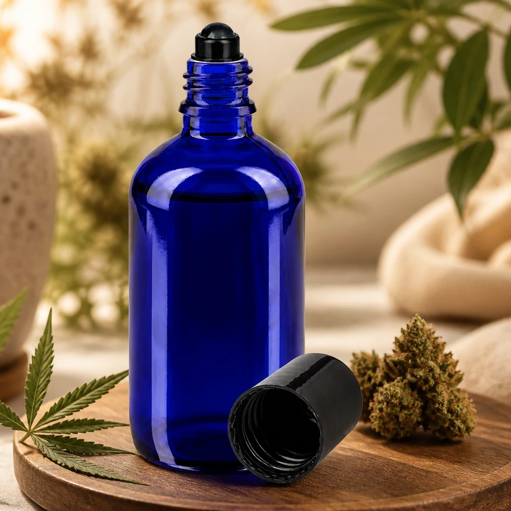 Flacone roll-on 100ml blu STD nero ApoGlas Flacone roll-on blu da 100 ml in vetro da farmacia accanto a un fiore di cannabis e a una foglia di canapa su un tagliere di legno