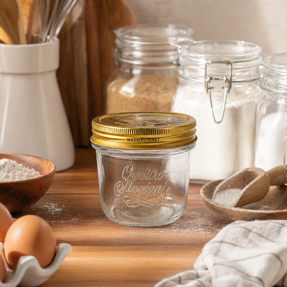 Bicchieri "Quattro Stagioni" da 200 ml con coperchio Bicchieri Quattro Stagioni da 200 ml con coperchio dorato su tavola di legno accanto a farina, uova e utensili da cucina Made in Italy
