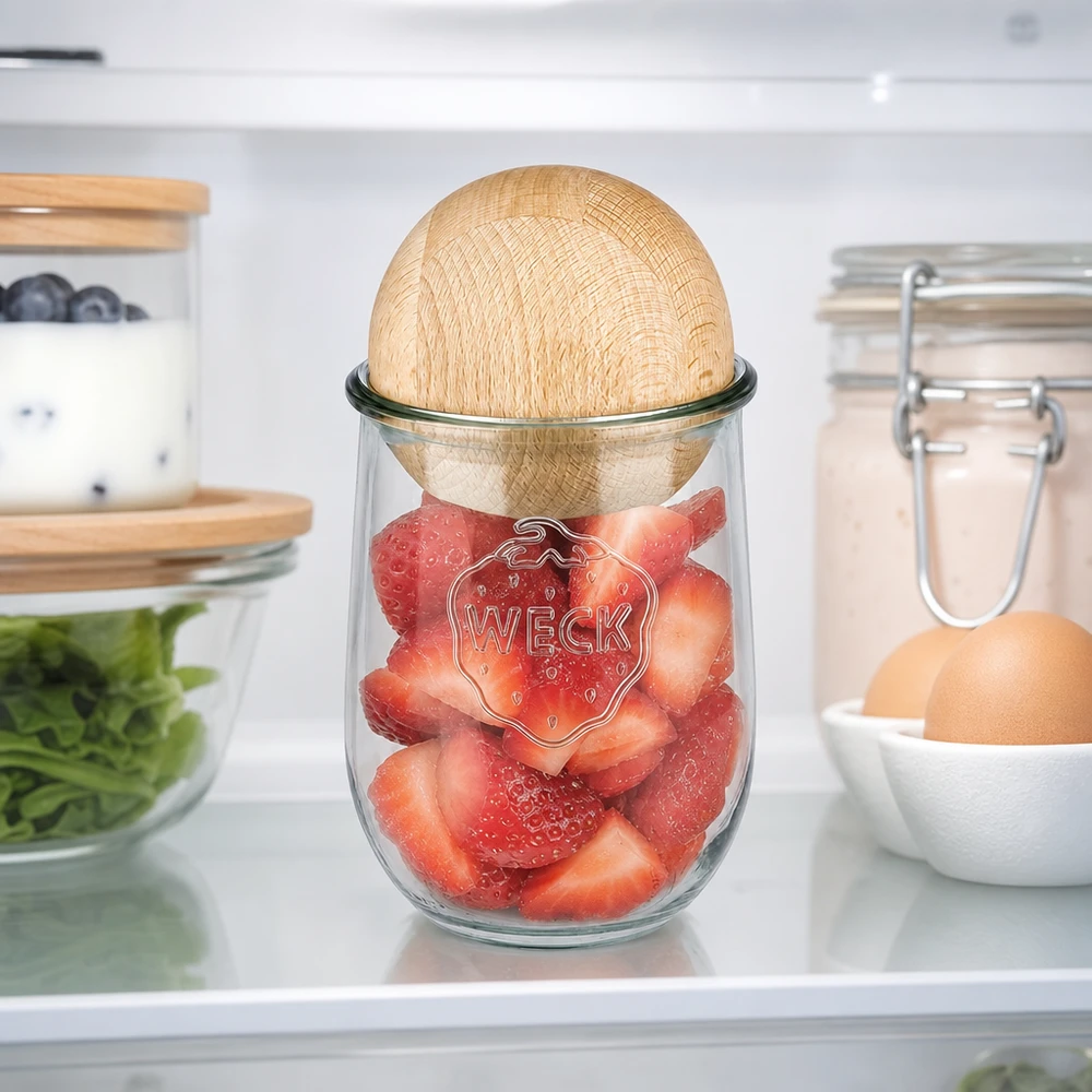 Il vaso a tulipano WECK 1062ml RR100 con sfera di faggio in frigorifero, riempito di fragole fresche, mostra una conservazione ottimale della freschezza.