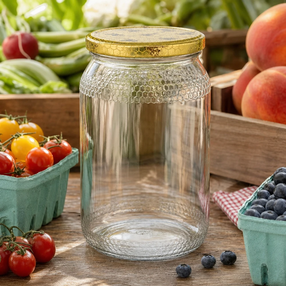 Vasetto per miele da 1260 g con capsula bianca BasicSeal UNiTWIST Vaso di miele da 900 ml vuoto con coperchio dorato a nido d'ape tra frutta e verdura fresca su un tavolo da cucina in legno