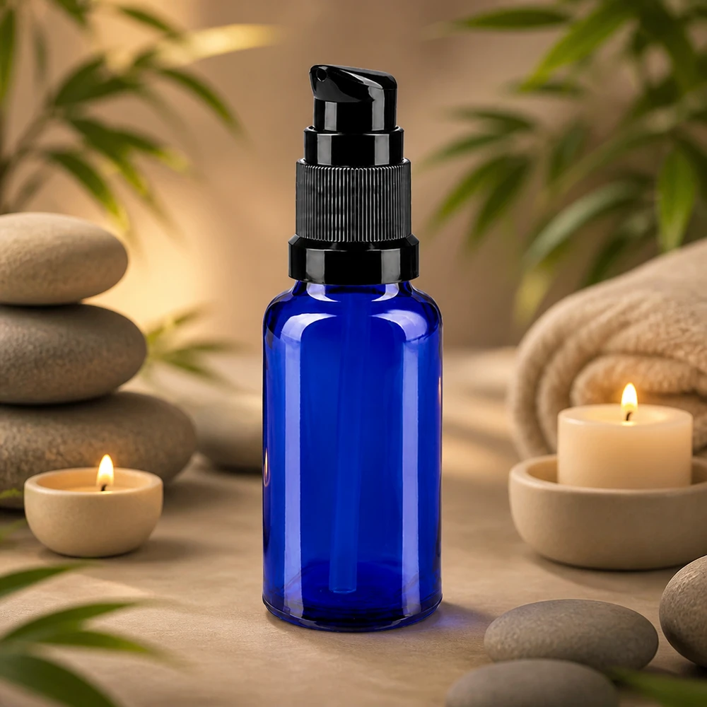 Flacone blu da 20 ml con dosatore, in vetro da farmacia, con dosatore nero, accanto a pietre da massaggio e candele