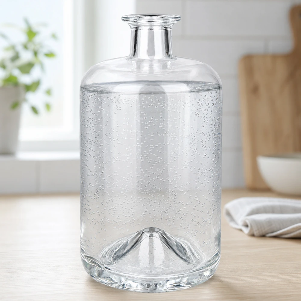 La bottiglia di vetro Sofia da 700 ml riempita di acqua frizzante mostra le bolle di anidride carbonica in un ambiente di cucina luminoso