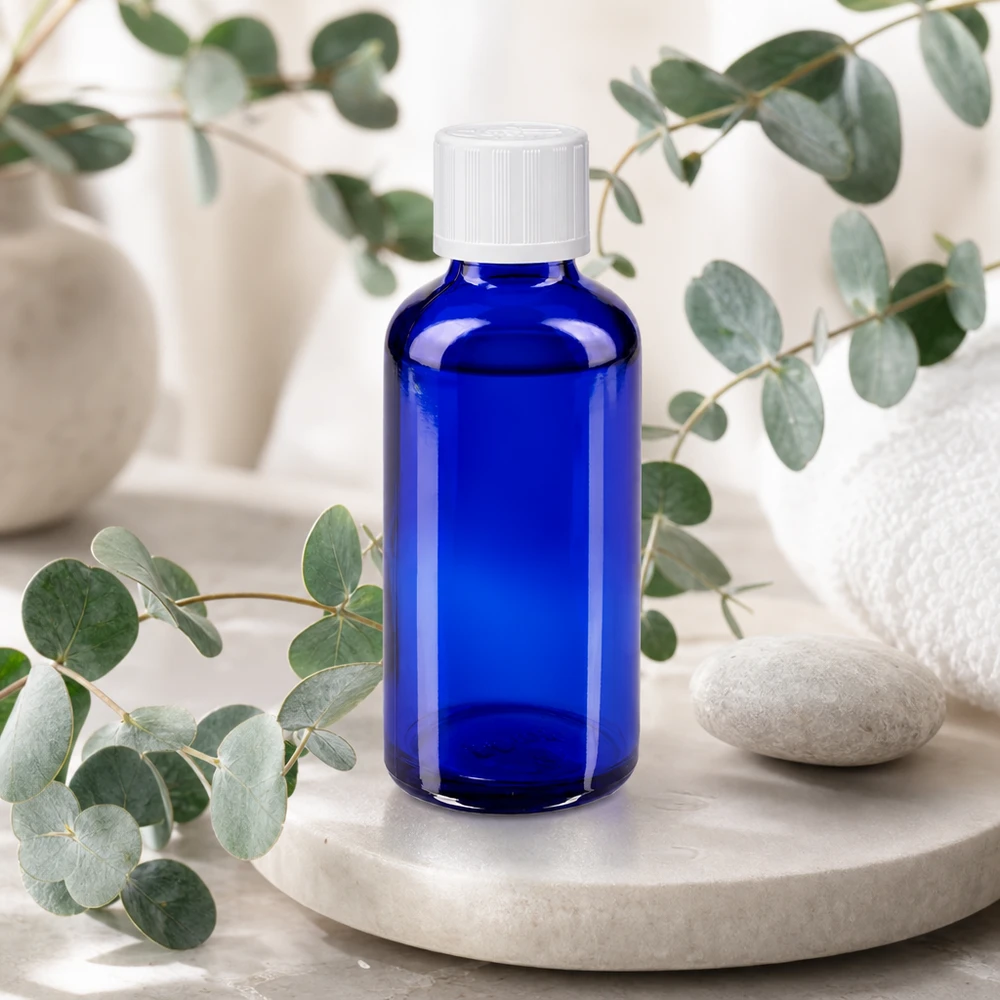 Flacone da farmacia da 50 ml blu con tappo di sicurezza bianco su vassoio in marmo con eucalipto