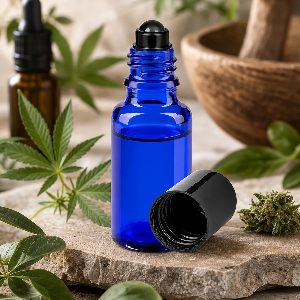 Flacone roll-on 20ml blu STD nero ApoGlas Piccolo flacone roll-on da 20 ml in vetro da farmacia blu accanto a una pianta di cannabis e a un mortaio