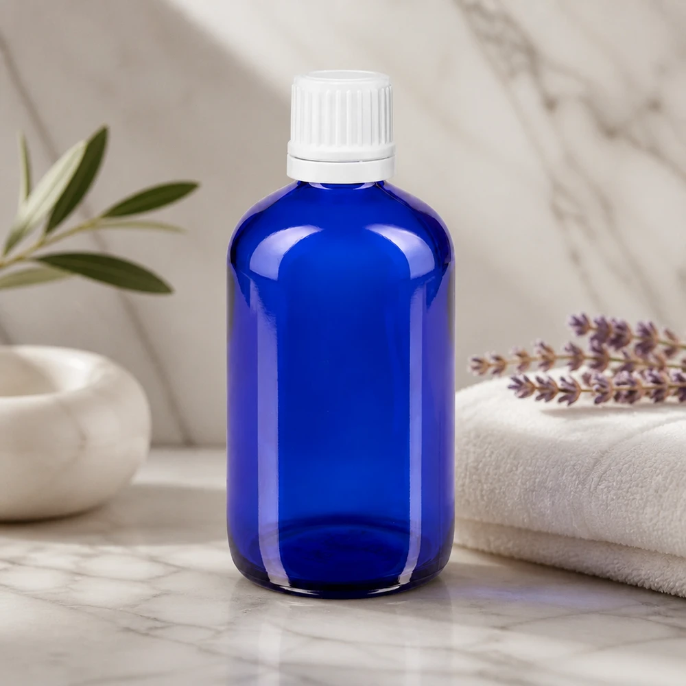 Flacone contagocce blu da 100 ml in vetro da farmacia con tappo OV bianco su fondo marmorizzato