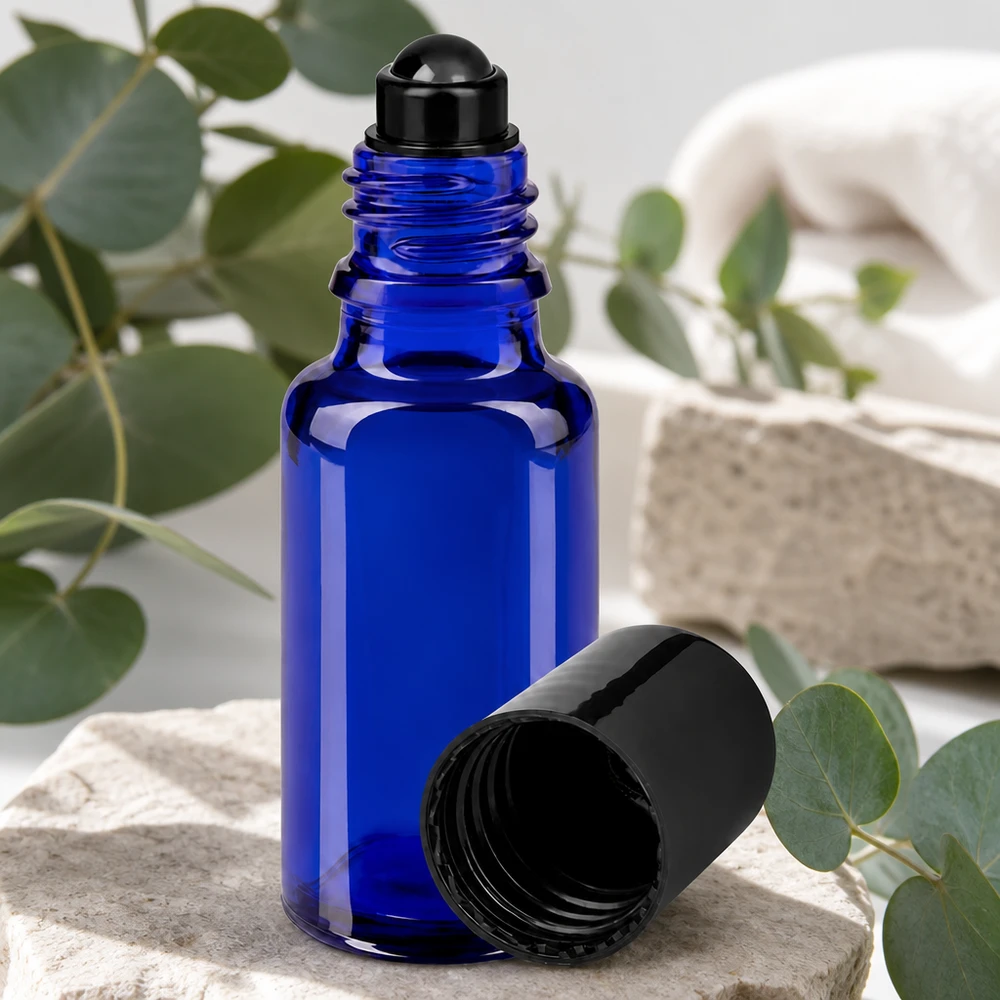 Flacone roll-on 20ml blu STD nero ApoGlas Flacone roll-on in vetro da farmacia blu da 20 ml con applicatore a sfera nero e tappo aperto