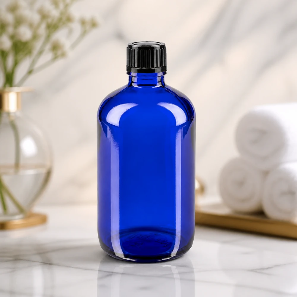 Bottiglia da farmacia blu da 100 ml. SV STD nero/11mm ApoGlas Bottiglia cilindrica in vetro blu da 100 ml con tappo a vite nero scanalato su superficie in marmo