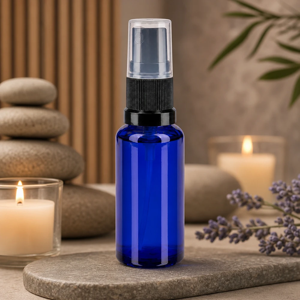 Piccolo flacone spray da 30 ml in vetro da farmacia blu cobalto con erogatore nero su fondo in pietra