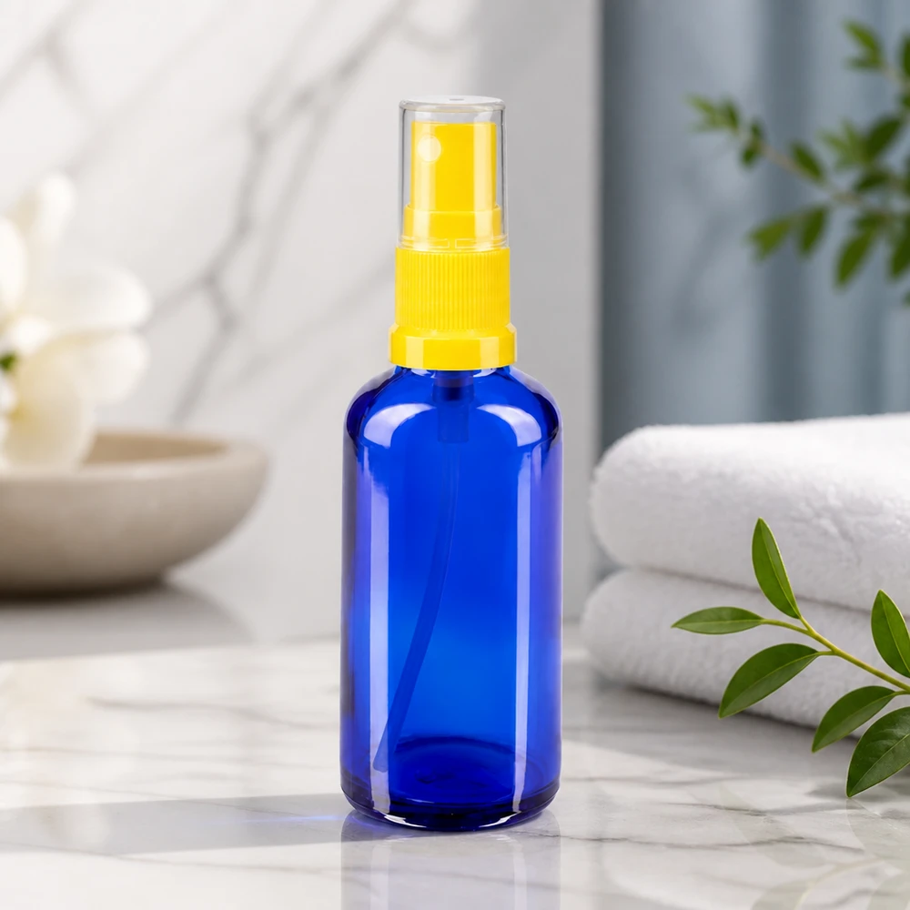 Flacone da farmacia in vetro blu da 50 ml con nebulizzatore giallo su fondo marmorizzato