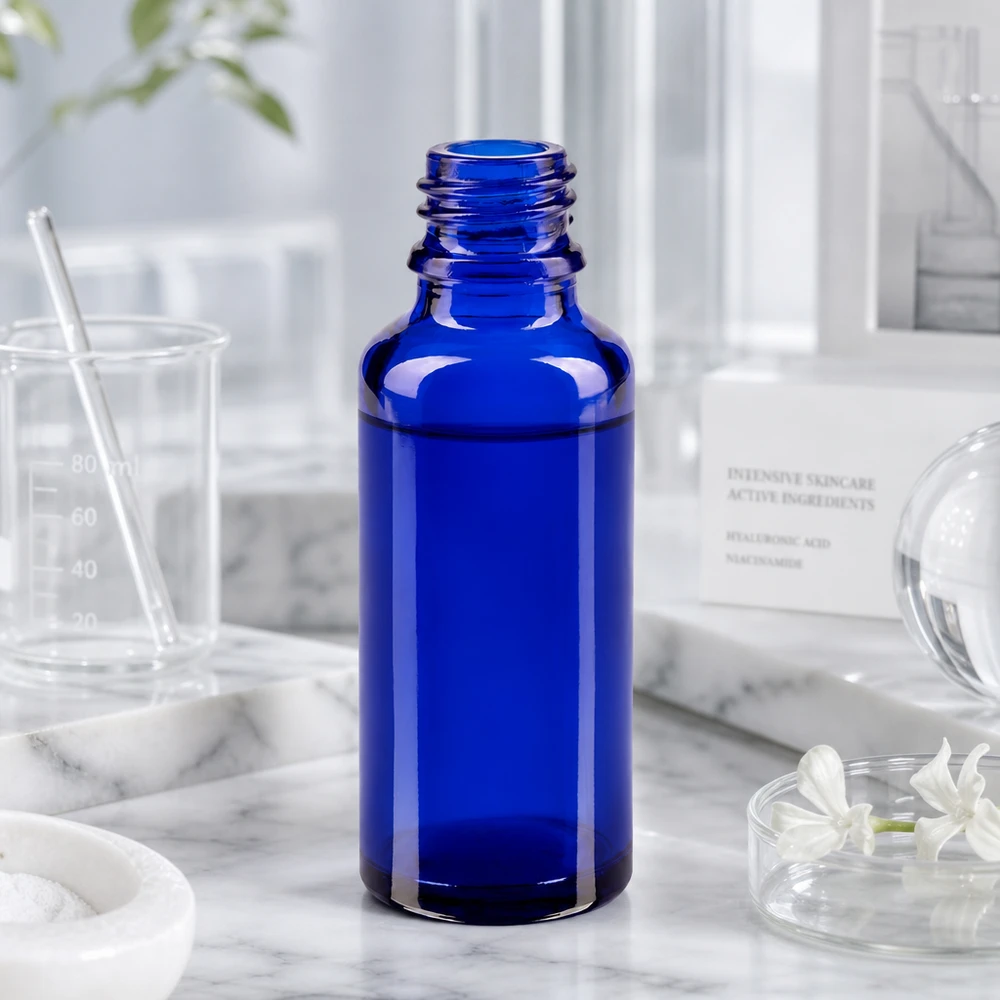 Flacone ApoGlas da 30 ml blu cobalto in ambiente di laboratorio, con misurino e ingredienti per la cura della pelle