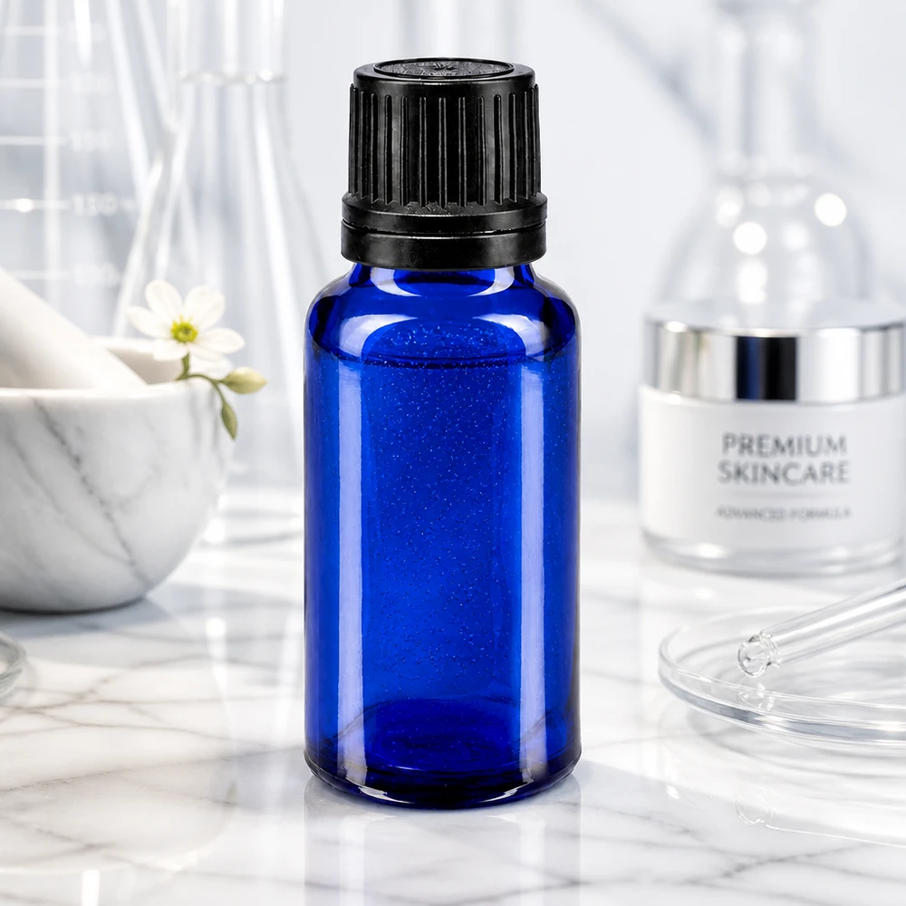 Flacone di vetro blu da 20 ml con tappo a vite nero, davanti a strumenti di laboratorio in vetro su uno sfondo di marmo