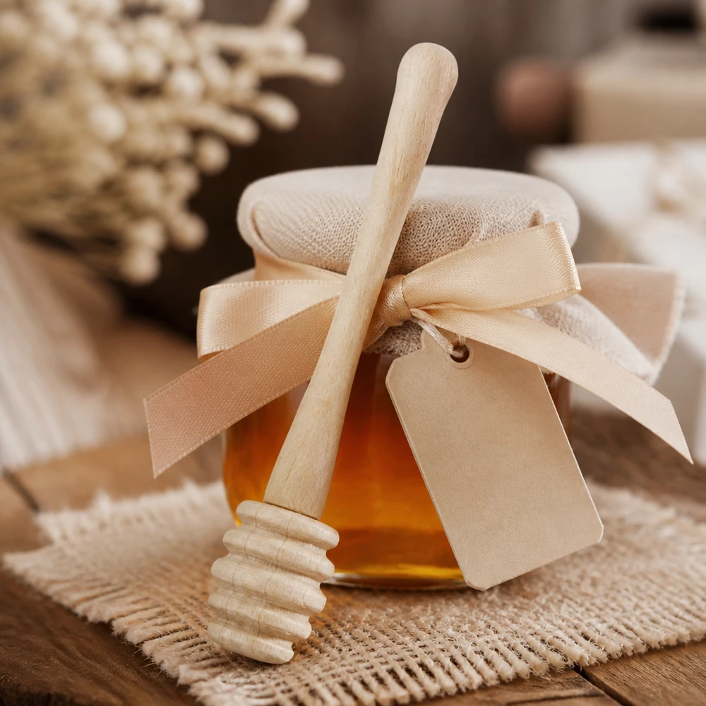 Cucchiaio da miele in legno d'acero con confezione regalo e nastro, accanto a favi di miele su sfondo di juta