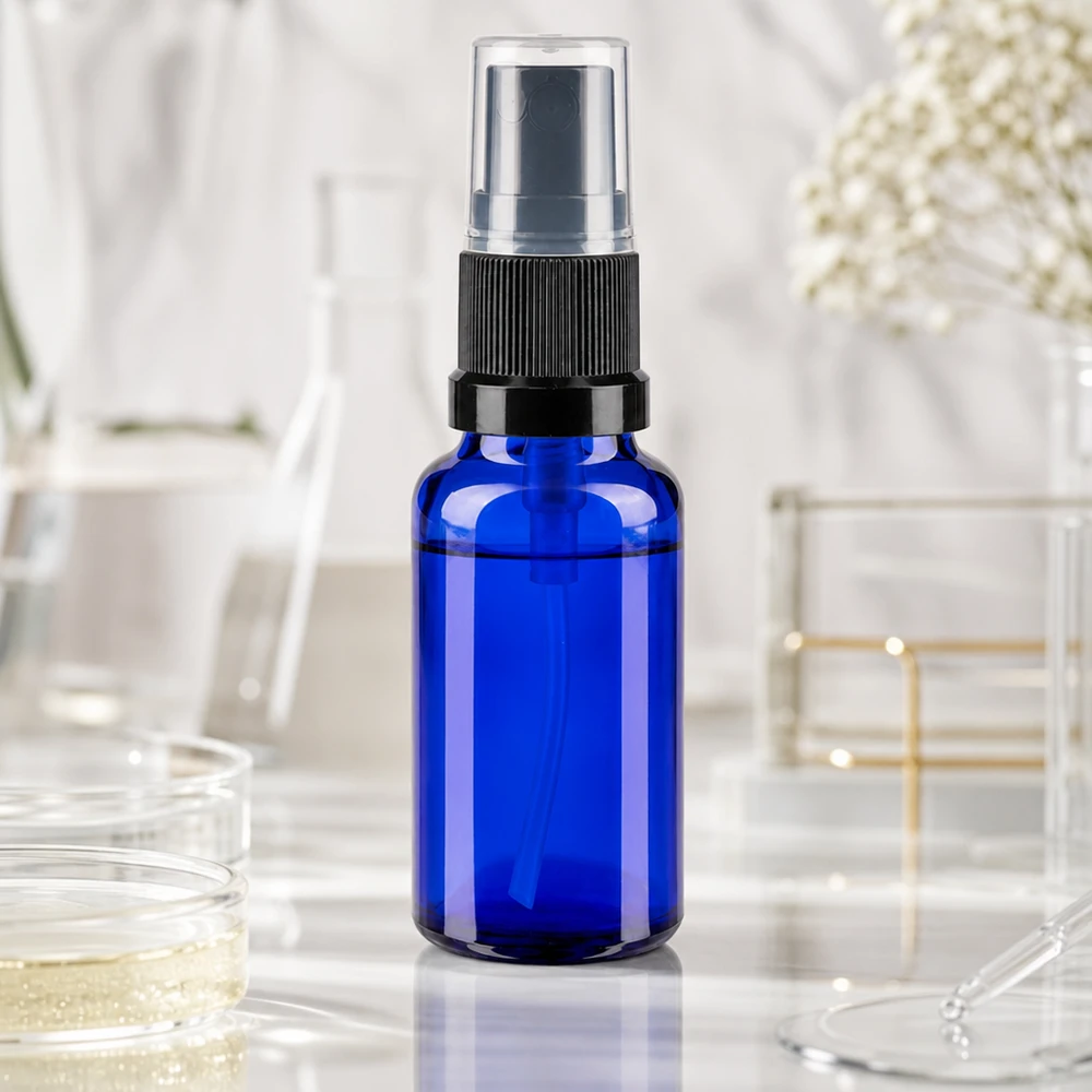 Flacone spray da laboratorio blu da 20 ml con nebulizzatore nero su sfondo di marmo bianco