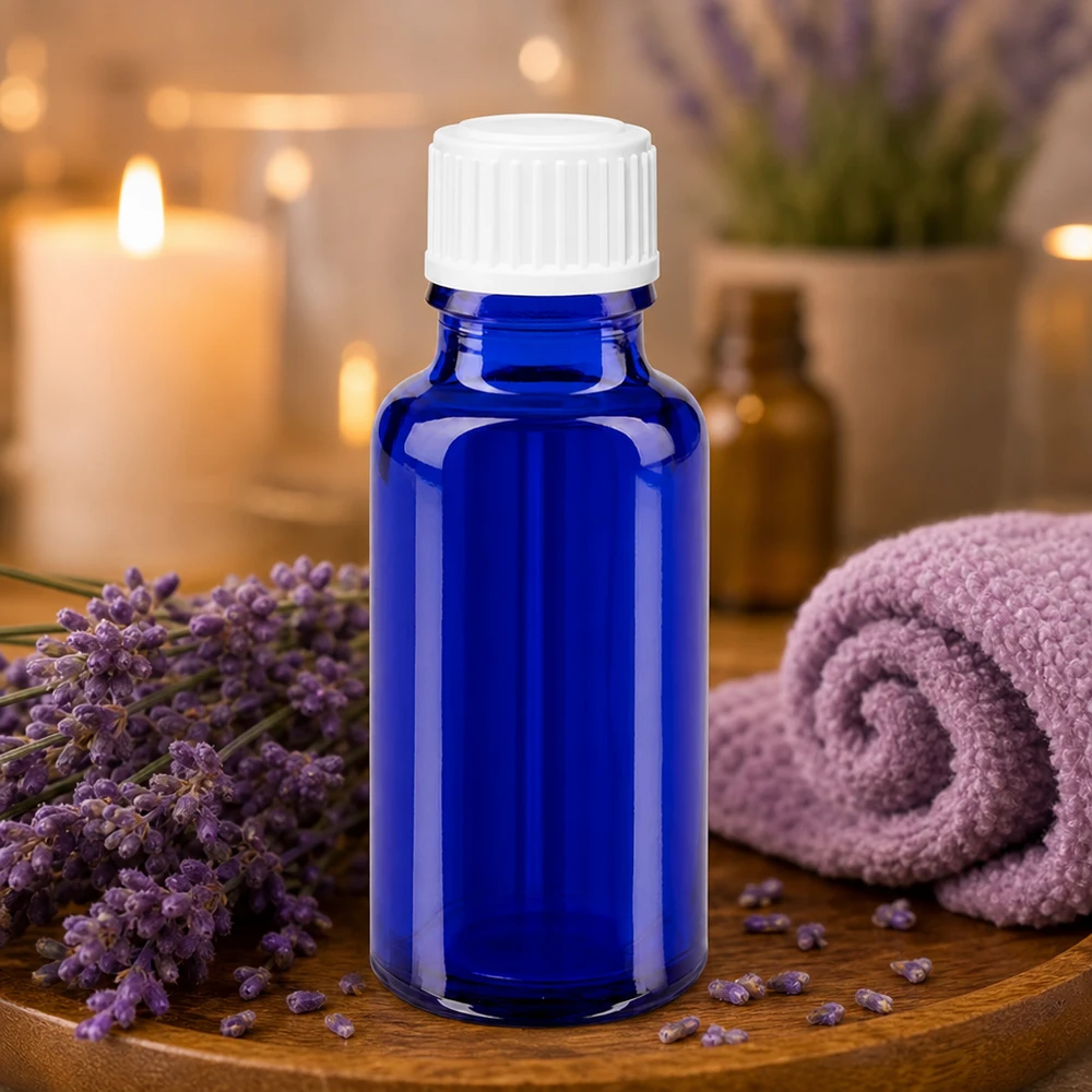 Flacone di vetro blu da 20 ml con tappo bianco, circondato da fiori di lavanda su un vassoio di legno