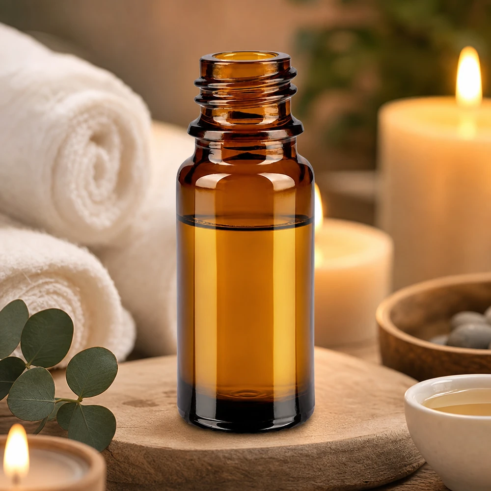 Flacone marrone da 10 ml di ApoGlas con oli essenziali tra asciugamani bianchi e candele accese.