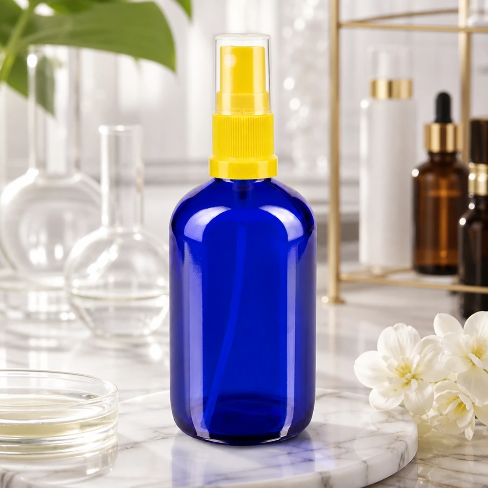 Flacone di vetro blu da 100 ml con erogatore a spruzzo giallo; protezione dai raggi UV grazie al vetro da farmacia blu cobalto