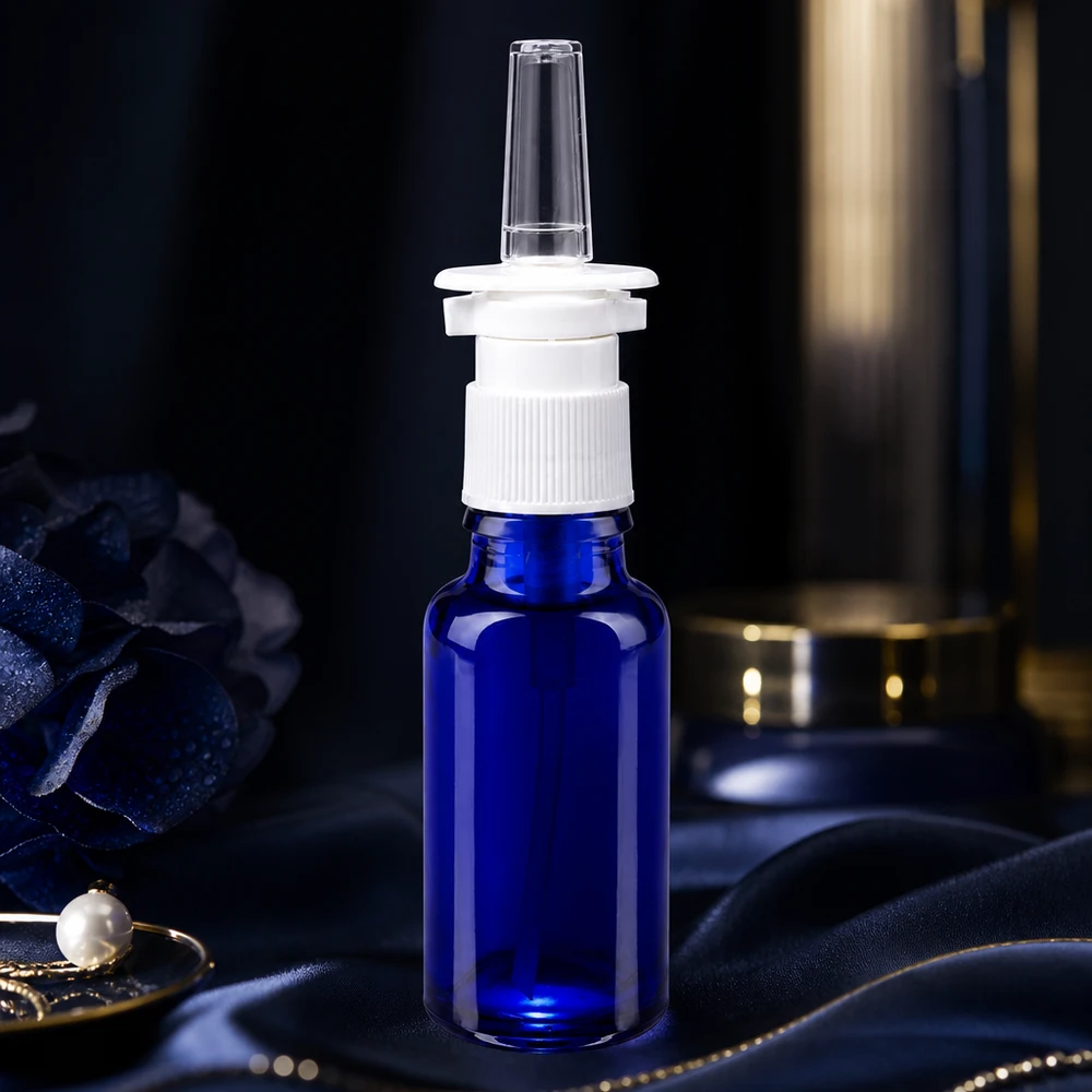 Flacone blu da 20 ml per spray nasale in vetro da farmacia con erogatore bianco su tessuto di seta