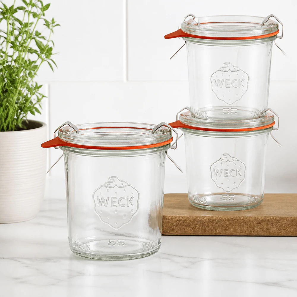 Tre tumbler WECK 140ml RR60 impilati su una tavola di legno in una cucina moderna con una pianta verde sullo sfondo