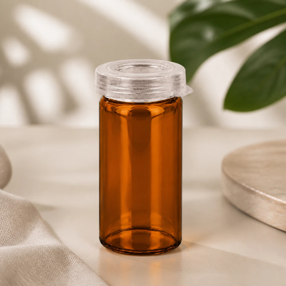Barattolo da tavolo con bordo a rotolo da 5 ml trasparente con coperchio a scatto Tubetto per compresse in vetro color ambra da 5 ml con tappo a scatto in plastica trasparente su sfondo chiaro